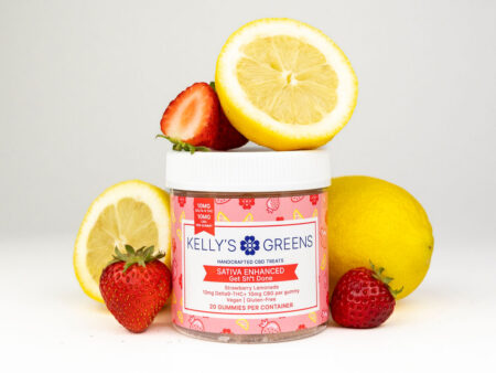 An image of a container with Strawberry Lemonade fruit chews with 10mg Delta-9 THC surrounded by lemons and strawberries on a white background.