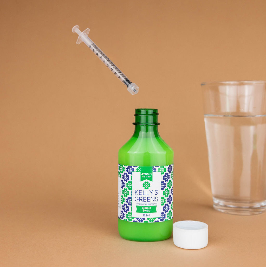 Precision dropper dispensing simple syrup into a glass of water
